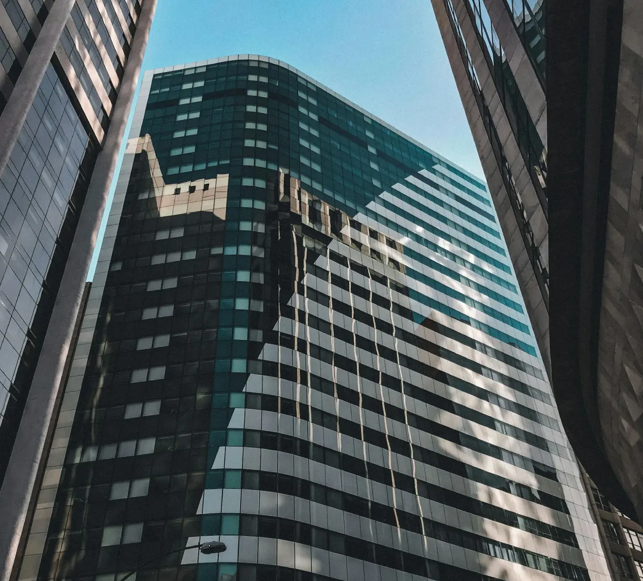 Modern glass building with detailed structural patterns representing tax due diligence and analytical review